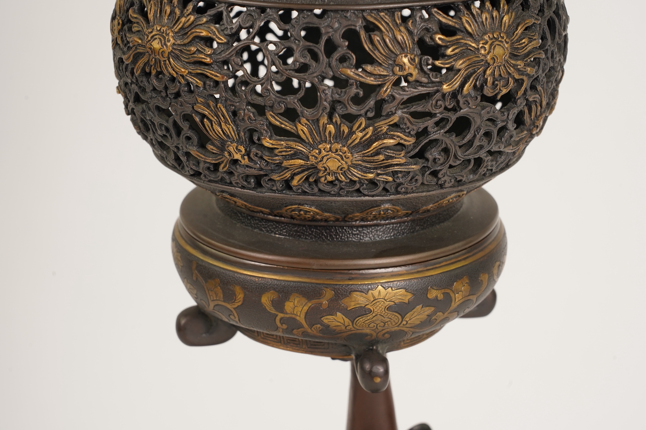 A large Japanese Miyao style parcel gilt bronze figure holding a koro aloft, 20th century